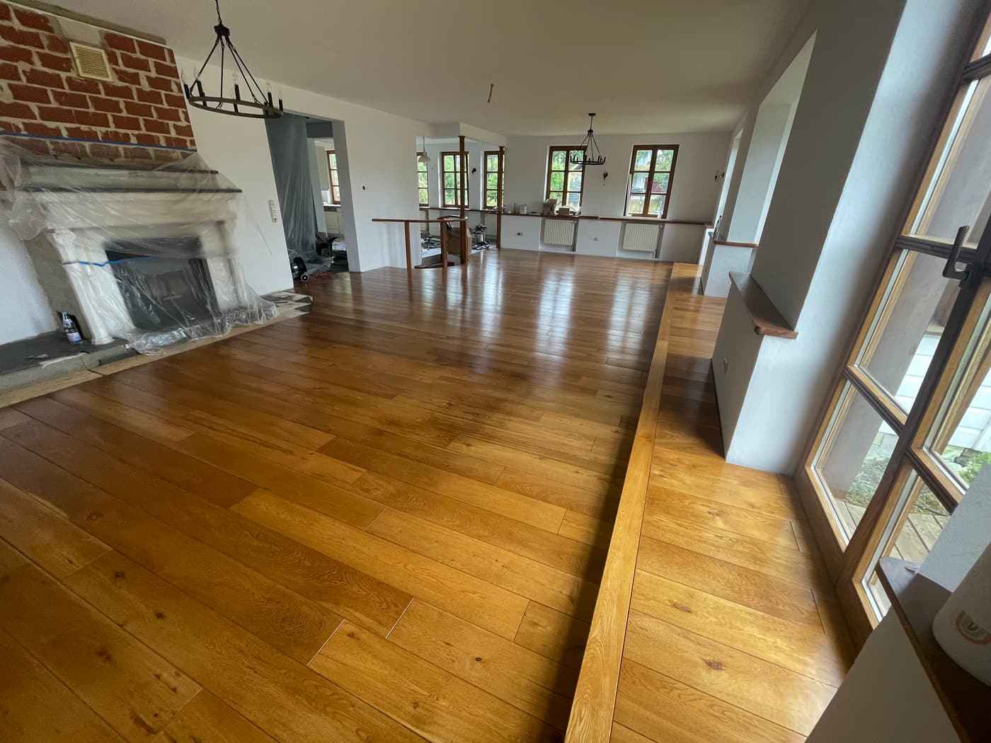 Renovierter Wohnraum mit Parkettboden, Kamin und Sprossenfenstern